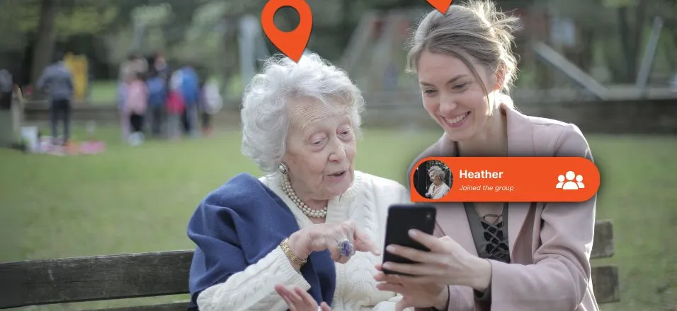 An older woman being introduced to the Device Tracker Plus app on a bench in a park