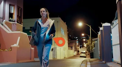 A female medical worker walking alone down a city street at night