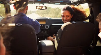 An excited family on a road trip in a car