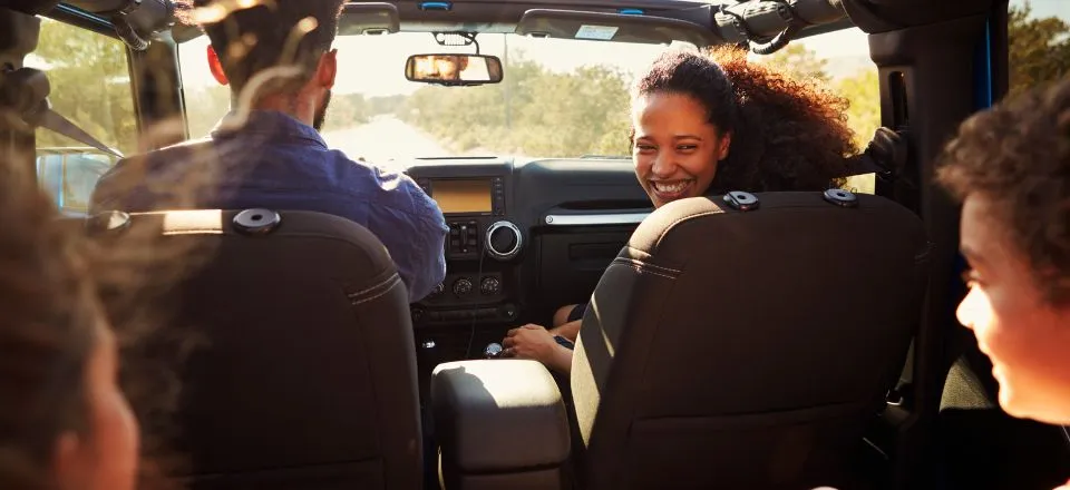 An excited family on a road trip in a car